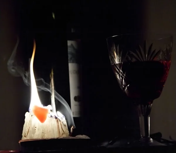 Glass with wine and burning candle — Stock Photo, Image