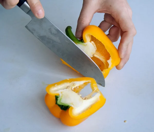 Human hand cutting pepper with knife — Stock Photo, Image