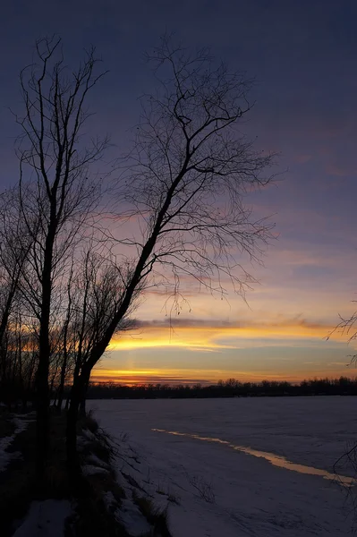 Закат над замерзшей рекой — стоковое фото