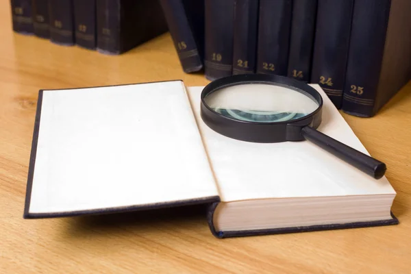 Close-up of magnifying glass on a book w — Stock Photo, Image