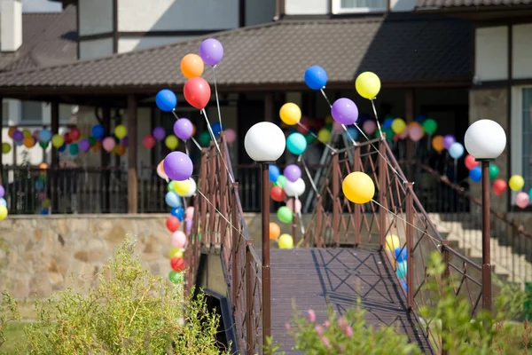 Colorful helium baloons on bridge that l — Stock Photo, Image