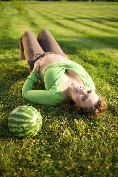 Mulher grávida na grama com melão — Fotografia de Stock