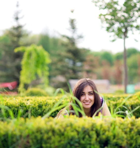 Menina se escondendo sobre arbusto — Fotografia de Stock