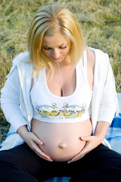 Mujer embarazada mirando en el vientre —  Fotos de Stock