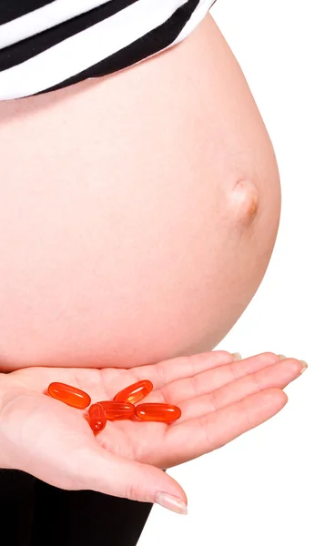 Belly of pregnant woman with capsules — Stock Photo, Image