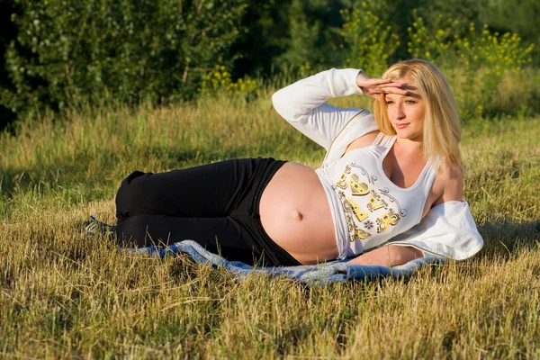 Mulher grávida bonita descansando sobre o — Fotografia de Stock