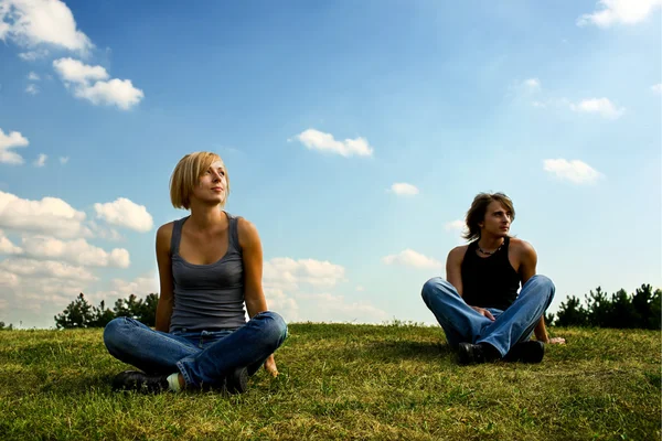 两个年轻人坐在草地上 — 图库照片