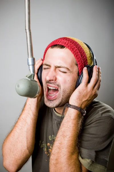 Νεαρός άνδρας τραγουδά στο μικρόφωνο — Φωτογραφία Αρχείου