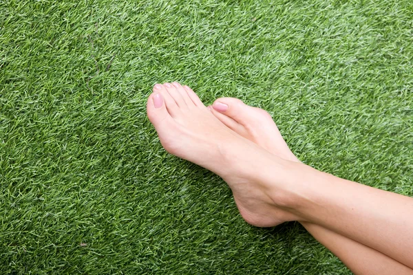 Belos pés femininos magros na grama — Fotografia de Stock