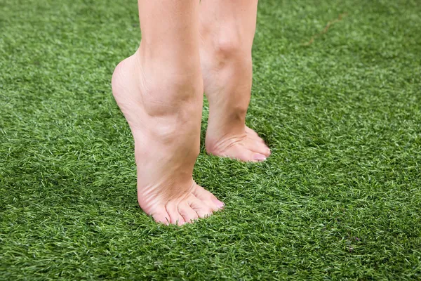 Hermoso delgado pies femeninos en la hierba —  Fotos de Stock