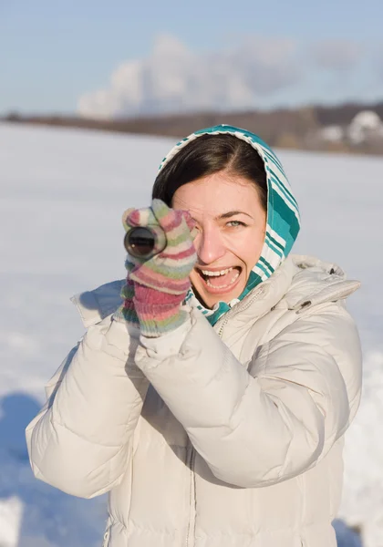 Chica en pañuelo echar un vistazo en spyglass en la nieve — Foto de Stock