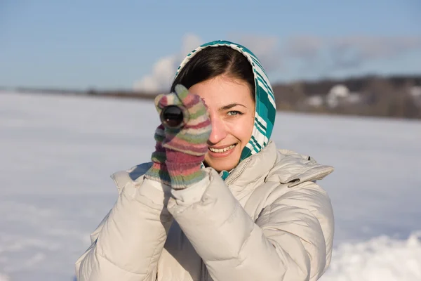 stock image Girl in kerchief take a look in spyglass on snow