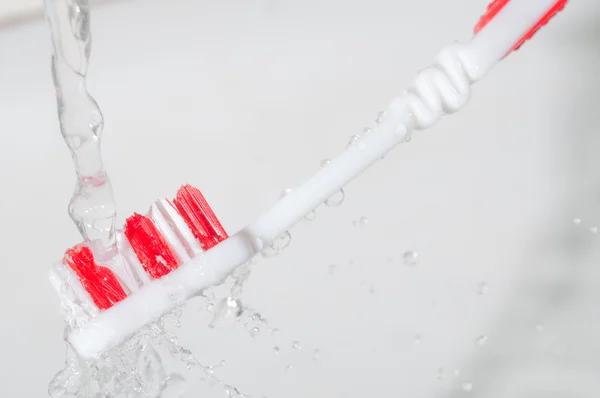 Tandenborstel in een waterplons — Stockfoto