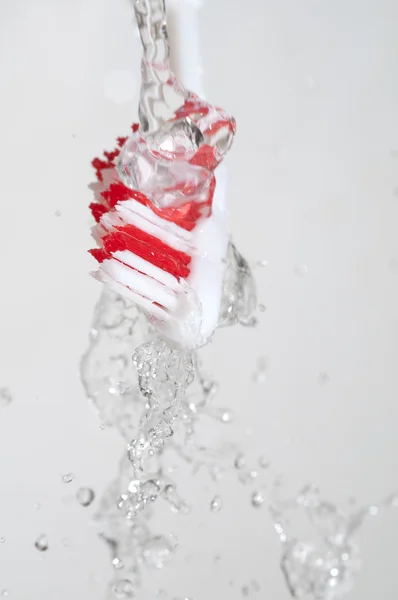 Cepillo de dientes en un chorro de agua — Foto de Stock