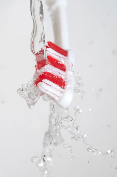 Tandenborstel in een waterplons — Stockfoto