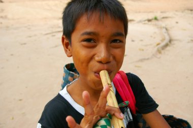 Flüt oynayan Asyalı çocuk