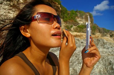 Asian woman applying makeup clipart