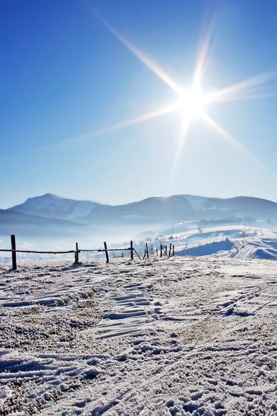 Fence in snow covered mountain under sky — Stock Photo, Image