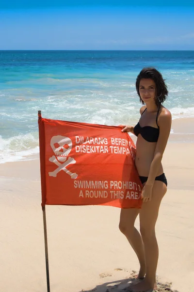 Woman with red flag on the sea — Stock Photo, Image
