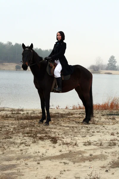 Vacker elegant kvinna som rider en häst — Stockfoto