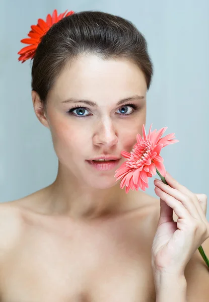 Portrait of young woman with red flower — Stock Photo, Image