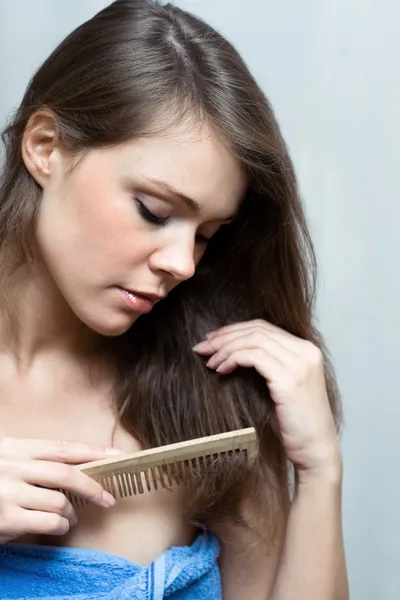 Mujer atractiva peinándose el pelo — Foto de Stock