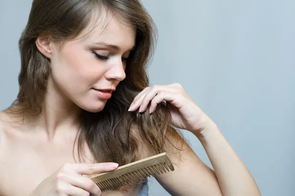 Mujer atractiva peinándose el pelo —  Fotos de Stock