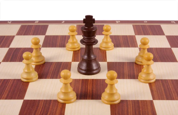 King surrounded by pawns on chess board — Stock Photo, Image