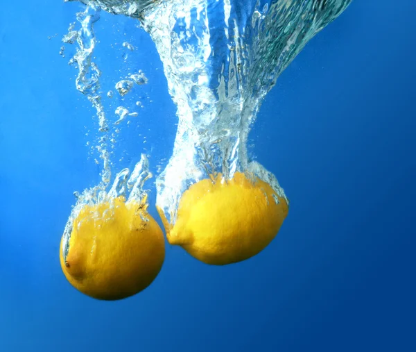 Dwie cytryny spadł do wody — Zdjęcie stockowe