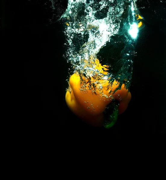 Yellow pepper in black water — Stock Photo, Image