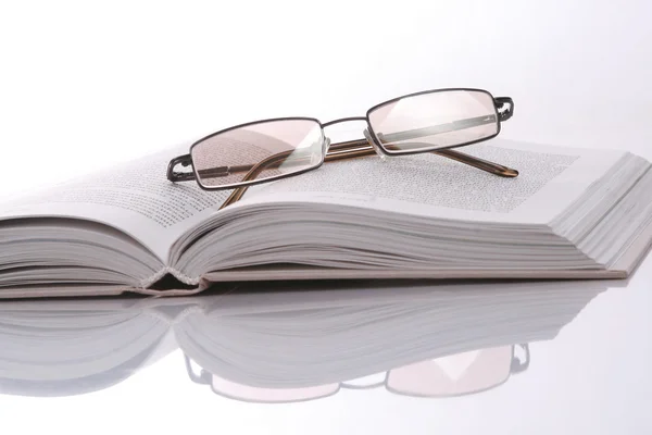 Buch und Brille isoliert auf weiß — Stockfoto