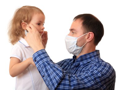 Baba kızı için tıbbi maske koyar.