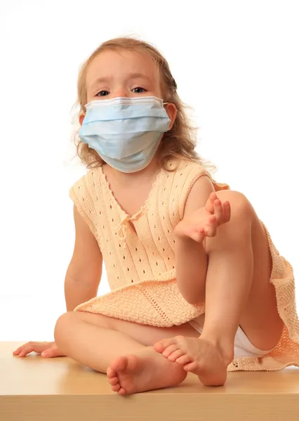 Menina está em uma máscara médica com um thermom — Fotografia de Stock
