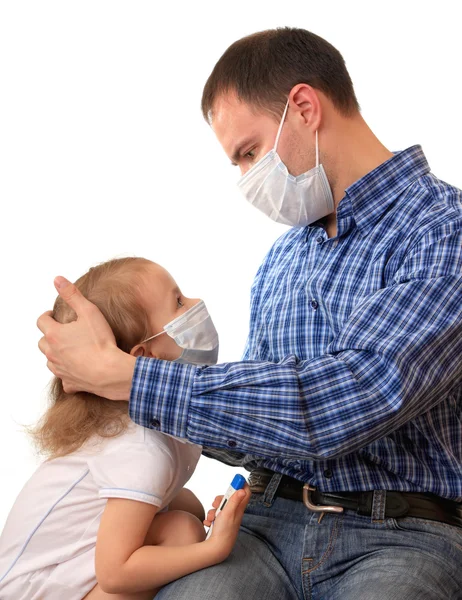 Семья в медицинских масках с термометром — стоковое фото