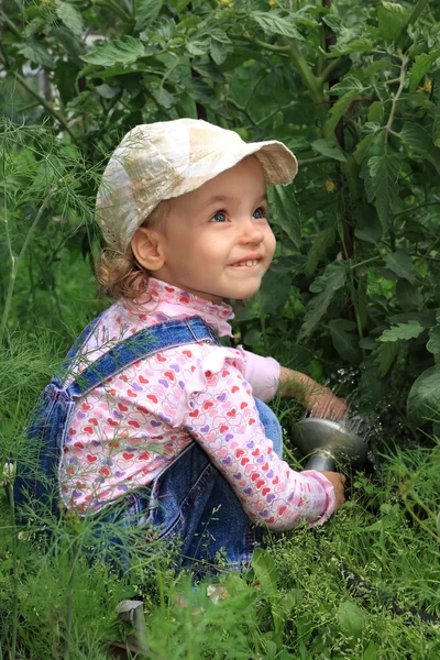 Dziewczynka nalewa ogród warzywny. — Zdjęcie stockowe