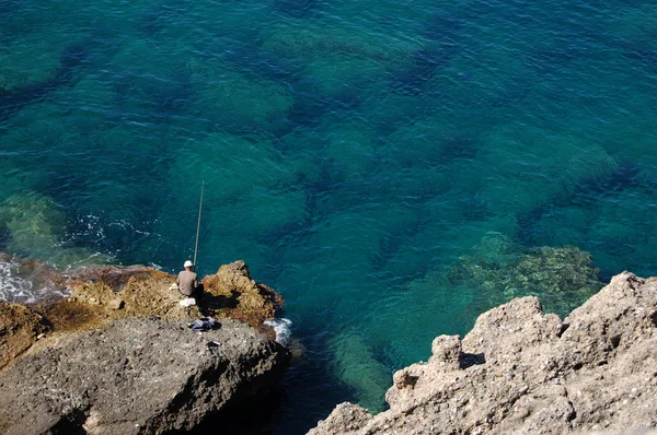 Pescador en una roca — Foto de Stock