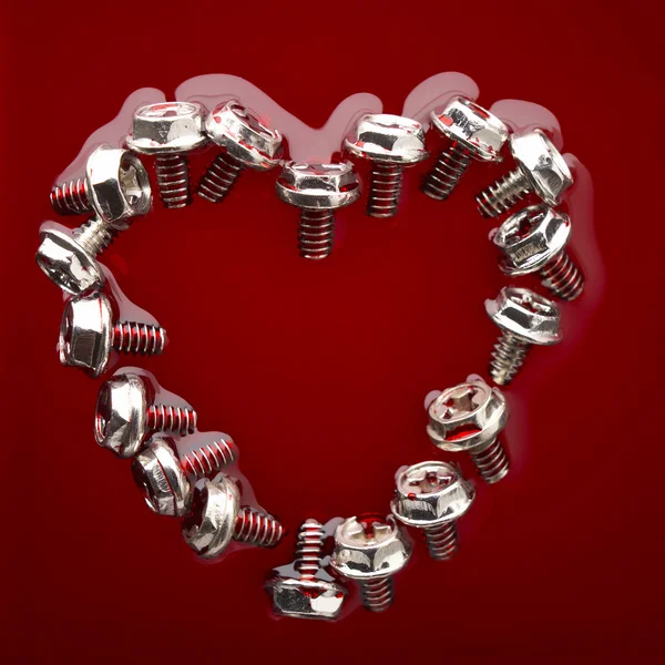 Heart from screws in red — Stock Photo, Image
