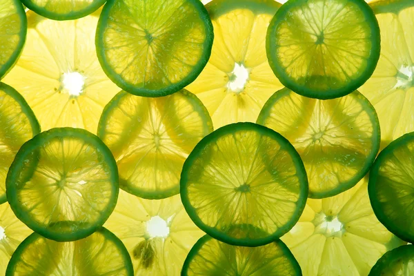 Limón amarillo y rodajas de limón verde — Foto de Stock