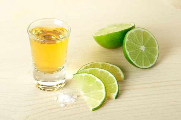 Gold Tequila with lime slices and salt — Stock Photo, Image