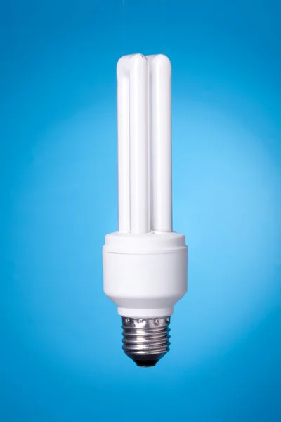 Energisparande lampa på blå bakgrund — Stockfoto