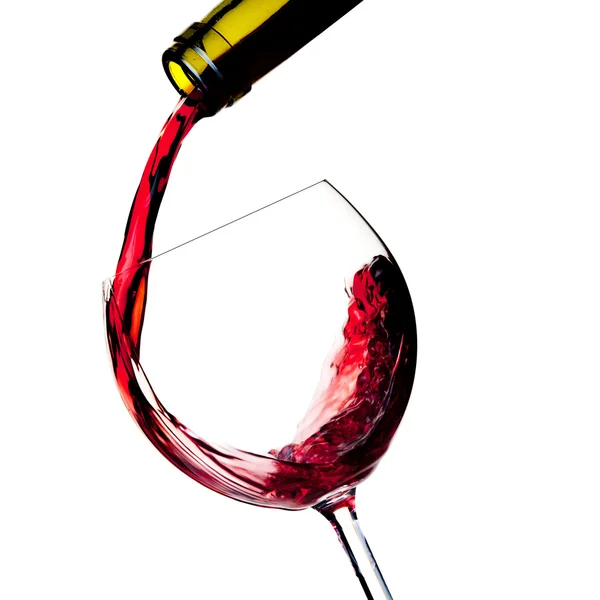 Rode wijn wordt in een glas gegoten — Stockfoto