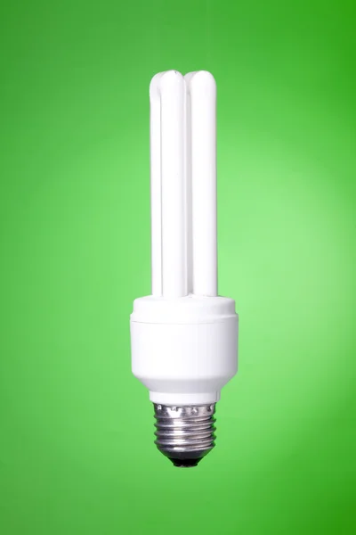 Energisparande lampa på grön bakgrund — Stockfoto