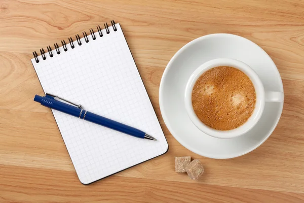 Bloco de notas em branco com caneta e copo de cappucino — Fotografia de Stock