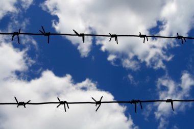 Barbed wire against blue sky clipart