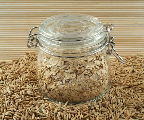 Oats and jar of oatmeal — Stock Photo, Image