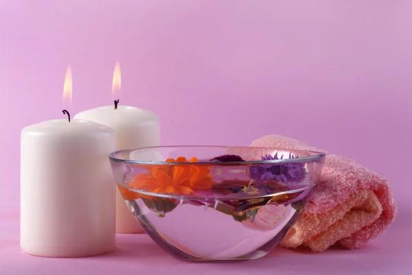 Ljus, skål med vatten och blommor — Stockfoto