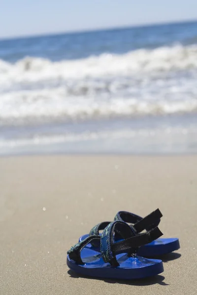 stock image A pair of sandals on a tropical beach