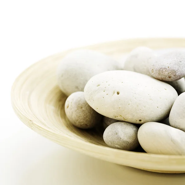 Pebbles in bamboo bowl — Stock Photo, Image