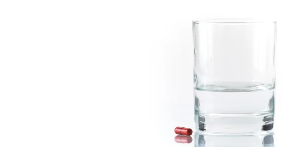 Gros plan sur la pilule rouge et l'eau — Photo