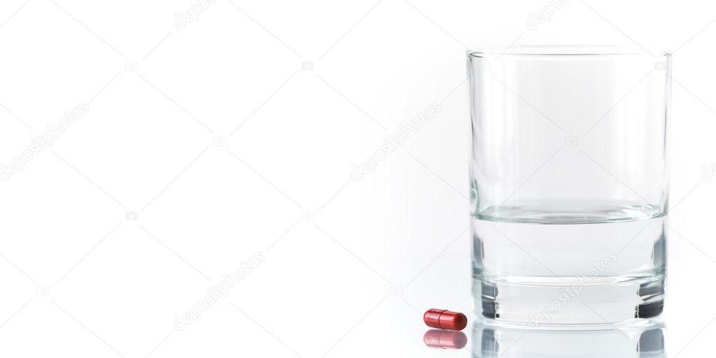 Close up of red pill and water